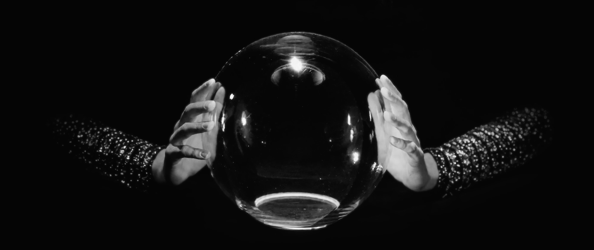 Two hands around a crystal ball