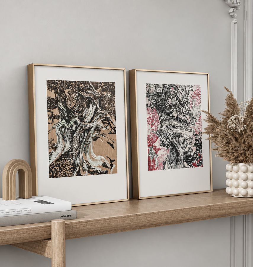 Two framed drawings of twisting trees, one on wood tone and one with red